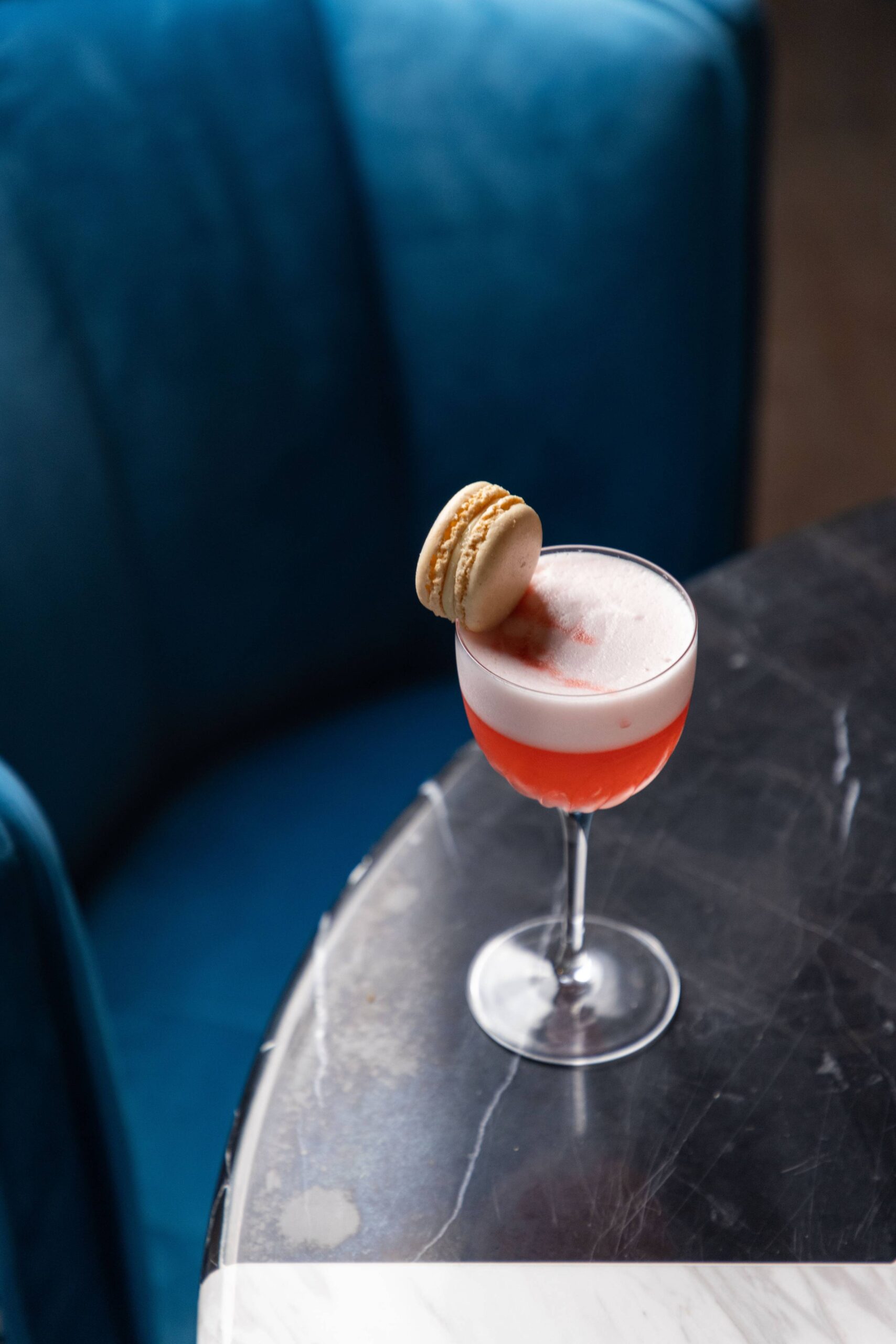 A tall red cocktail with fresh garnish